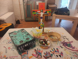 Tisch mit Kreuz, Kerze und Krokodil